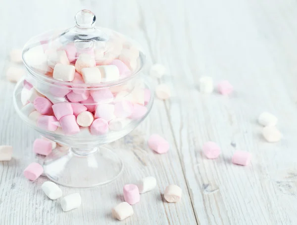 Marshmallows v krásné skleněné misky na dřevěný stůl — Stock fotografie