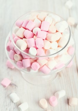 ahşap bir masa üzerinde güzel cam tabak içinde marshmallow