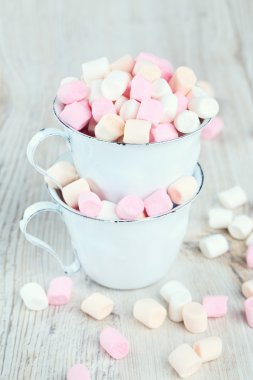 Marshmallow ahşap masa üzerinde metal bardak