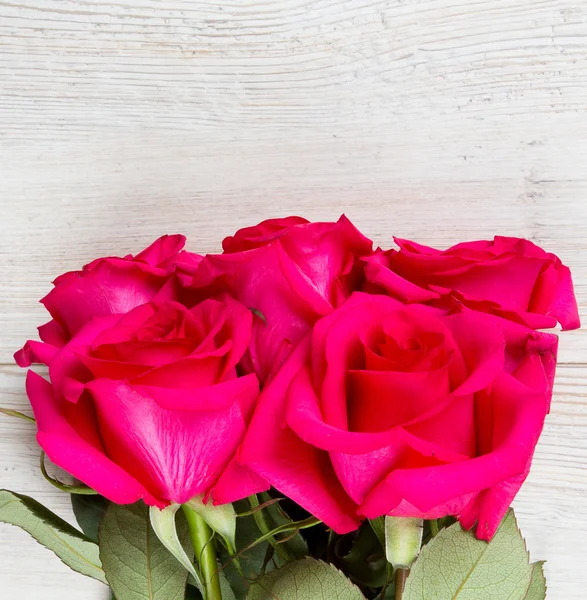 Mazzo di rosa su superficie di legno bianco — Foto Stock