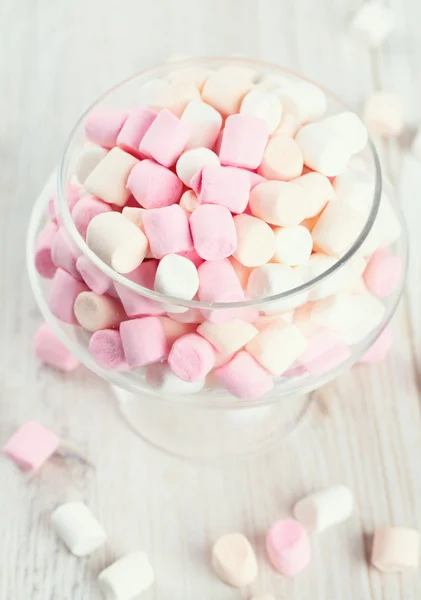 Marshmallows w pięknym szklanym naczyniu na drewnianym stole — Zdjęcie stockowe