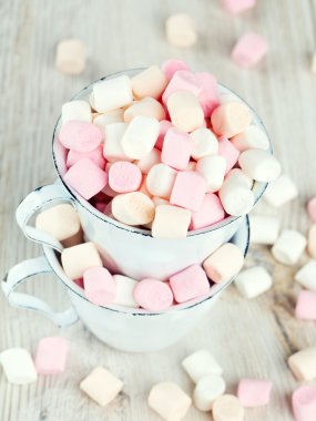 Marshmallow ahşap masa üzerinde metal bardak