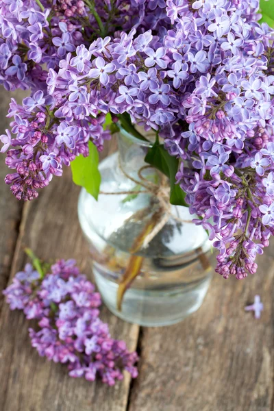 Beautiful lilac on dark wooden surface — Stock Photo, Image