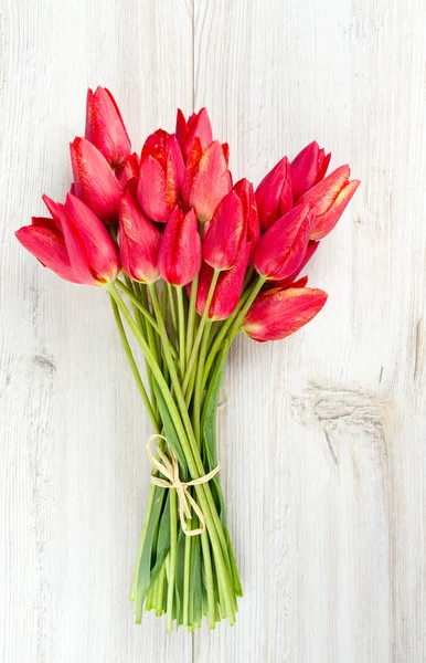 Bunch of red tulips on wooden surface — Stock Photo, Image