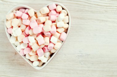 Marshmallow kalp şekli kase ahşap bir masa üzerinde