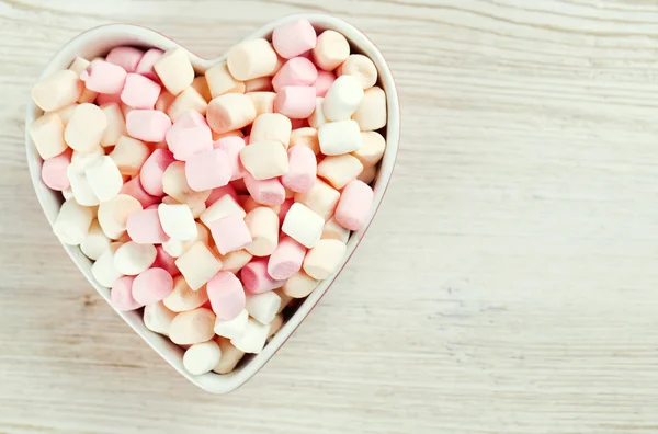 Marshmallows srdce tvar mísy na dřevěný stůl — Stock fotografie