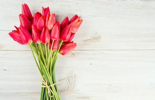 Kytice červených tulipánů na dřevěný povrch — Stock fotografie