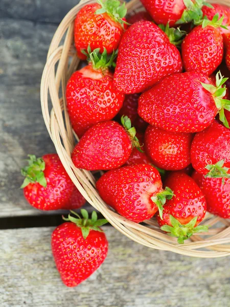 Cesta con fresas sobre una mesa de madera — Foto de Stock