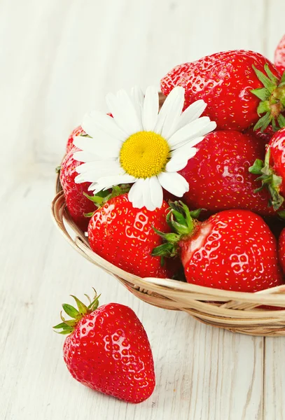 Cesta con fresas sobre una mesa de madera —  Fotos de Stock