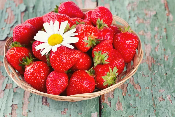 Korb mit Erdbeeren auf einem Holztisch — Stockfoto