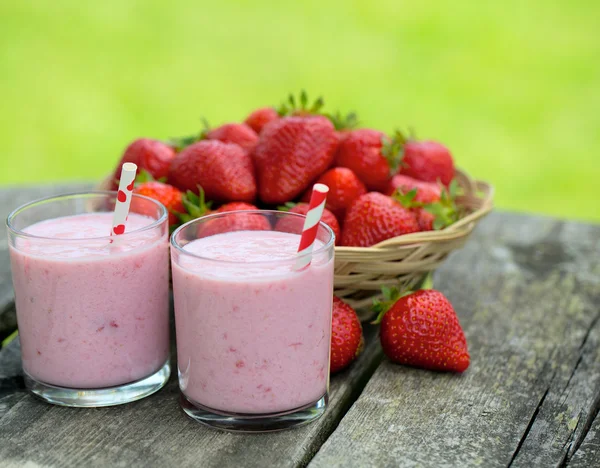 Batido de leite de morango na mesa de jardim de madeira — Fotografia de Stock