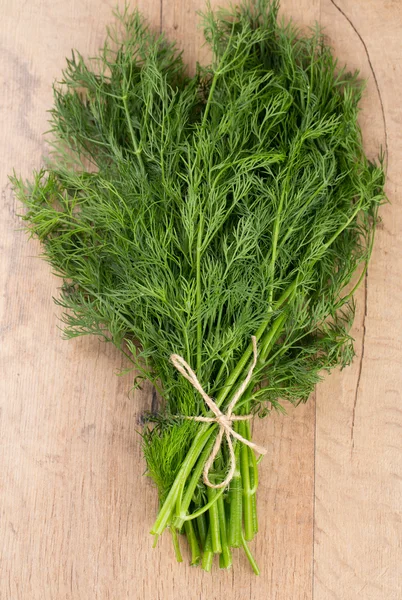 Bunch of dill on wooden surface — Stock Photo, Image