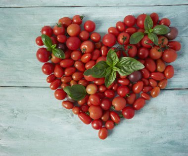 Turkuaz ahşap yüzeyde çeşitli minyatür domatesler