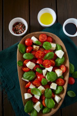Koyu ahşap yüzeyde Caprese salatası