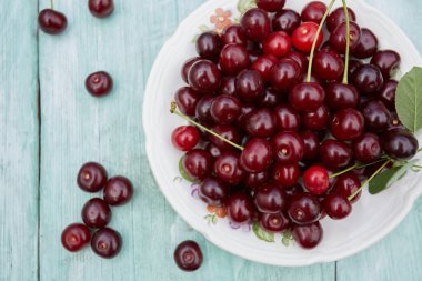 Turkuaz ahşap yüzeyde taze kirazlar.