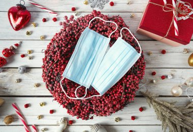 Güzel kırmızı çelenk ve yüz maskesi, Covid Noel konsepti.