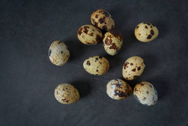 Karanlık taş yüzeyinde bıldırcın yumurtaları.