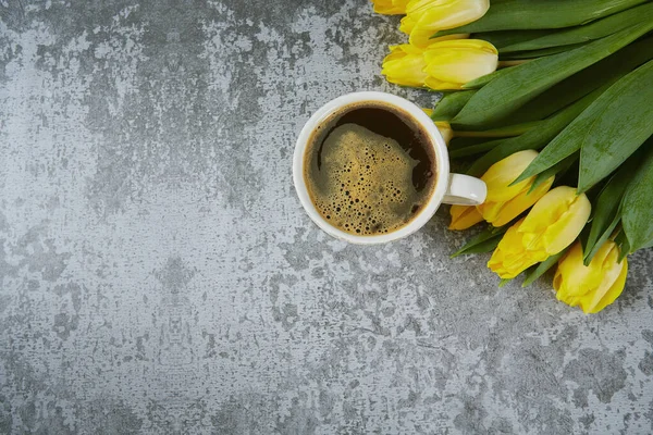 Tasse Schwarzen Kaffee Auf Steinoberfläche Und Strauß Gelber Tulpen — Stockfoto