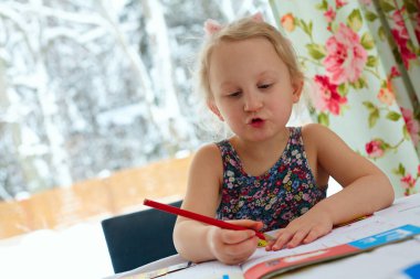 Sevimli küçük kız çiziyor.