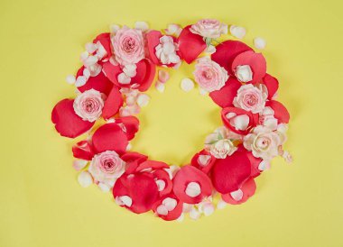 Sarı yüzeydeki gül yapraklarından yapılmış sınır