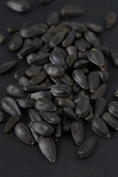 black sun flower seeds on black stone surface