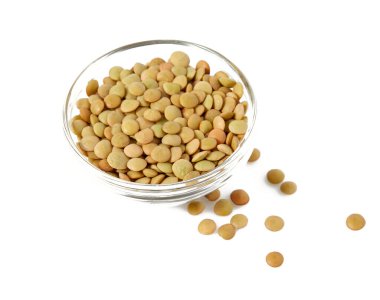 Beyaz arka planda izole edilmiş cam bir kasede yeşil mercimek.