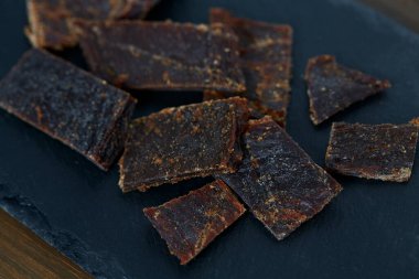 Siyah taş yüzeyde kurutulmuş et. Kurutulmuş et.