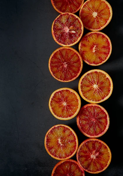 blood oranges on dark stone surface