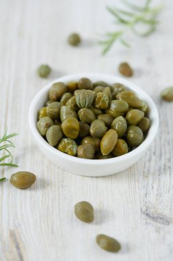 Beyaz ahşap yüzeyde turşulu kapari. Gurme yemekleri..