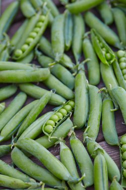 Tahta yüzeyde taze yeşil bezelyeler