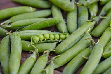 Tahta yüzeyde taze yeşil bezelyeler