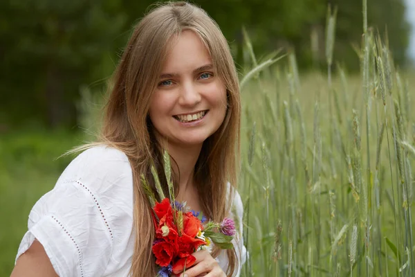 Красивая Молодая Женщина Держит Мак Кукурузные Цветы Против Летнего Поля — стоковое фото