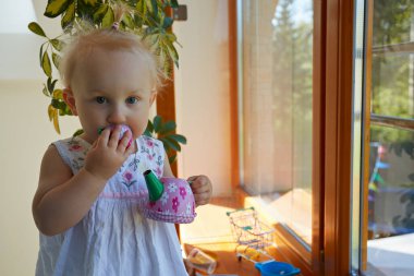 Şirin küçük kız oyuncak bardağından çay içiyormuş gibi yapıyor.