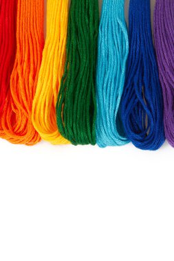 Beyaz arka planda izole edilmiş nakış işlemek için çok renkli iplikler. Gökkuşağı.