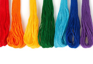 Beyaz arka planda izole edilmiş nakış işlemek için çok renkli iplikler. İpliklerden yapılmış gökkuşağı. Sanat ve zanaat. 