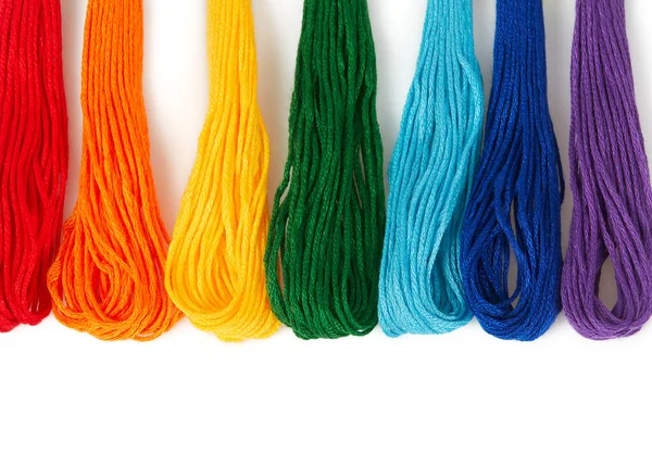 Beyaz arka planda izole edilmiş nakış işlemek için çok renkli iplikler. İpliklerden yapılmış gökkuşağı. Sanat ve zanaat. 