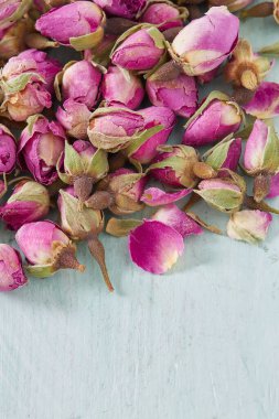 Turkuaz ahşap yüzeyde kurumuş gül tomurcukları