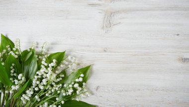 Beyaz ahşap yüzeydeki vadi zambakları.