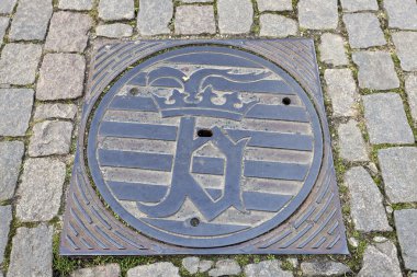 Kanalizasyon kapağı üzerinde Bruges amblemi
