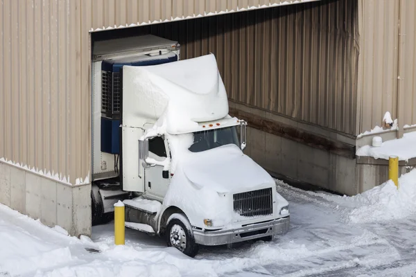 Semi truck and the warehouse seen winter time — Stock Photo, Image