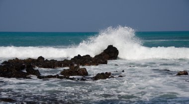 Morning surf breaks on rocks of Puako beach - 4 clipart
