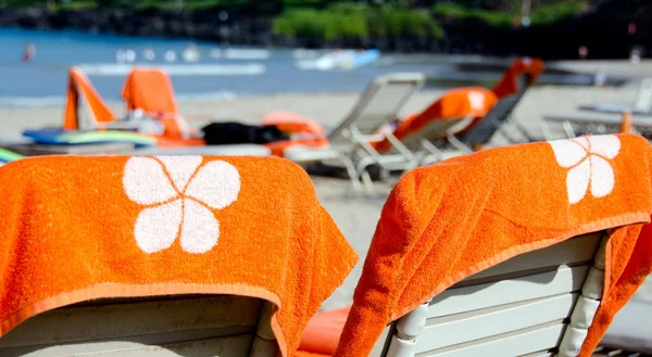 Bright orange beach towels and chairs at Kaunaoa beach