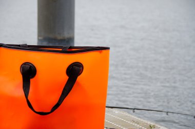 Turuncu çanta ve olta kamışı bir dock cihazı üzerindeki