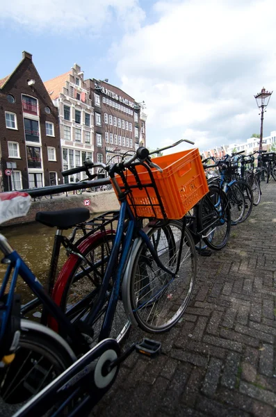 Велосипед с оранжевой пластиковой коробкой в Амстердаме — стоковое фото