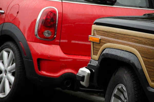 Old and modern cars parked next to each other under rain on Quee — Stock Photo, Image