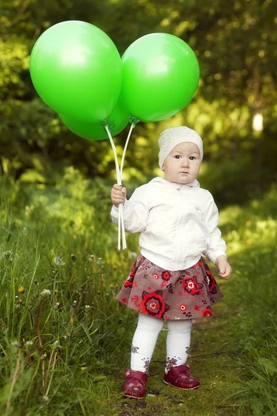 little girl with green balloons