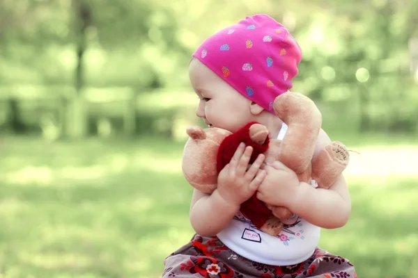 Kleines Mädchen legt einen Teddybär auf seine Hände — Stockfoto