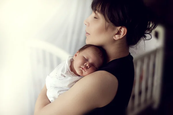 Mladá asijská matka něžně drží, spící na rameno o — Stock fotografie