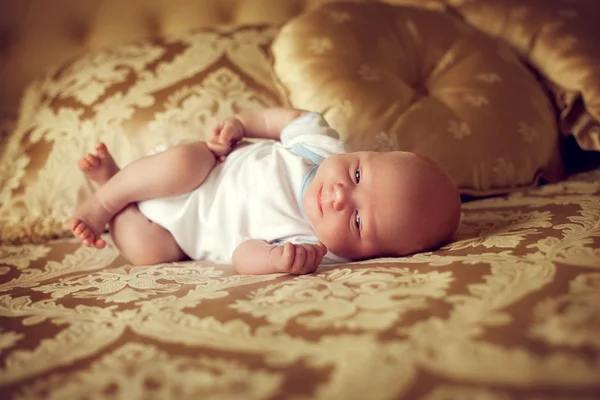 Newborn healthy baby 2 weeks old is lying in a posh bedroom on t — Stock Photo, Image