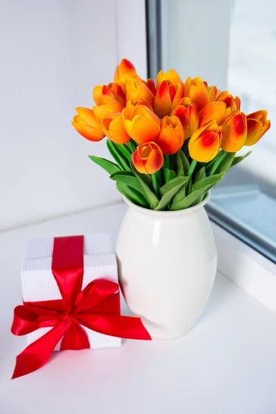 Schöne orange Tulpen und Geschenk-Box auf dem Fensterbrett — Stockfoto